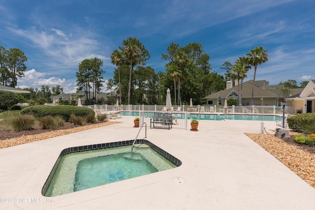 view of pool featuring a hot tub and a patio area