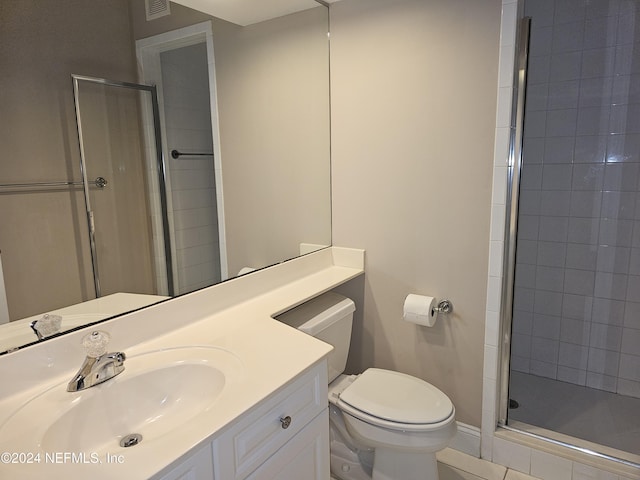 bathroom featuring vanity, a shower with shower door, and toilet