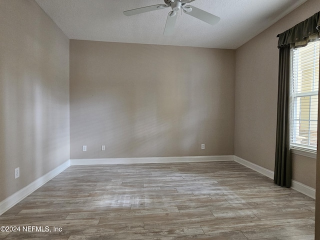 empty room with ceiling fan and light hardwood / wood-style floors