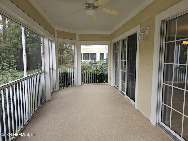 unfurnished sunroom featuring ceiling fan