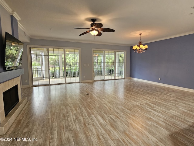 unfurnished living room featuring a tile fireplace, ceiling fan with notable chandelier, hardwood / wood-style floors, and crown molding