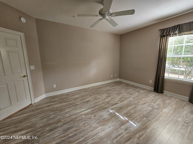 empty room with ceiling fan and light wood-type flooring