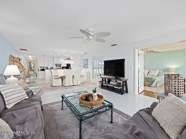 tiled living room featuring a textured ceiling and ceiling fan