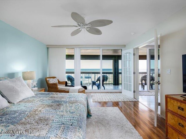 bedroom with access to exterior, ceiling fan, french doors, floor to ceiling windows, and hardwood / wood-style flooring