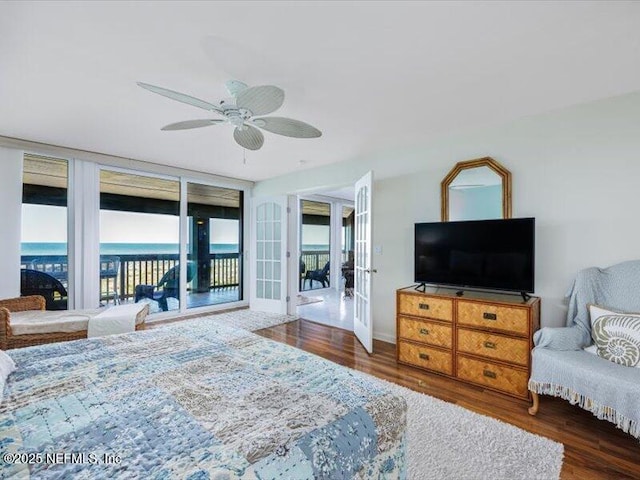 bedroom with french doors, expansive windows, access to outside, ceiling fan, and a water view