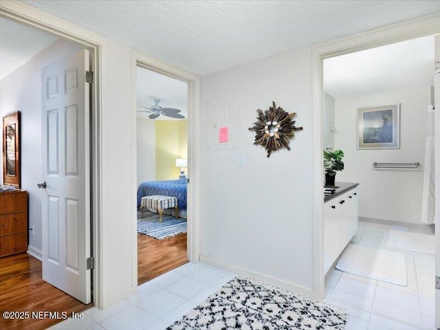 hallway featuring light tile patterned floors and a textured ceiling