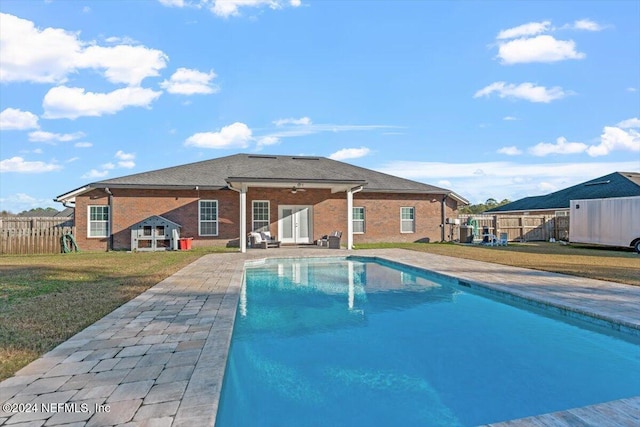 view of swimming pool featuring a lawn, ceiling fan, and a patio