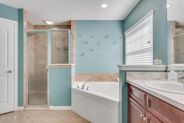 bathroom featuring vanity, a textured ceiling, and independent shower and bath