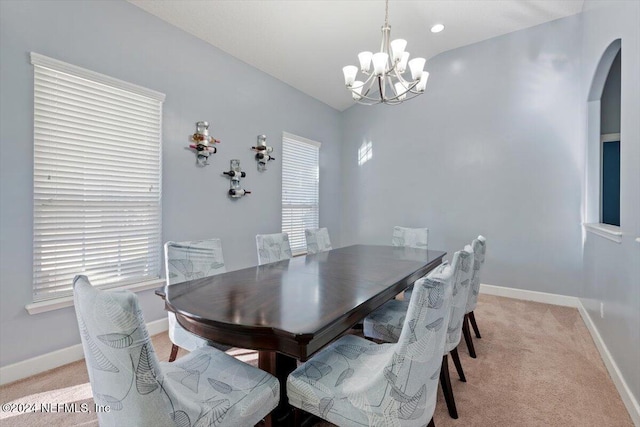 carpeted dining area with a notable chandelier