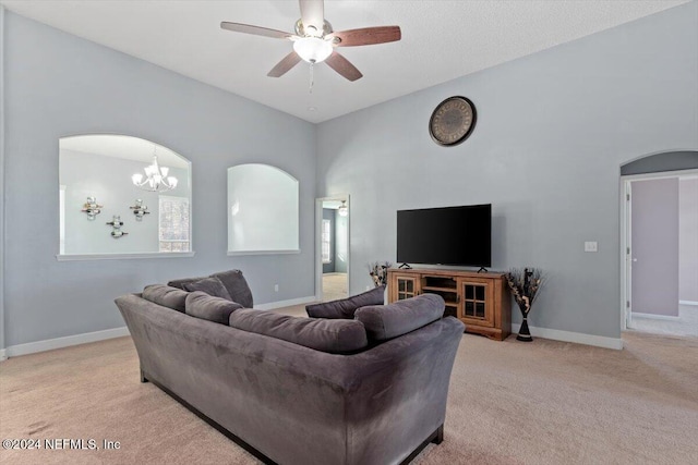 living room featuring light carpet and ceiling fan with notable chandelier