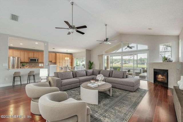 living room with vaulted ceiling, plenty of natural light, and dark wood-type flooring