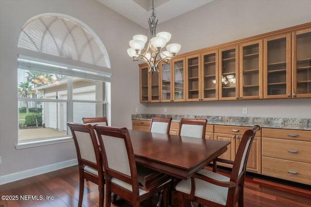 dining area with a chandelier, dark hardwood / wood-style floors, vaulted ceiling, and a healthy amount of sunlight