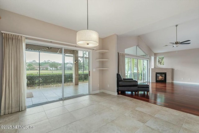 interior space with ceiling fan, light tile patterned flooring, and vaulted ceiling