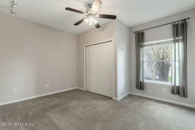 unfurnished bedroom with ceiling fan, a closet, and carpet