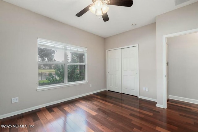 unfurnished bedroom with dark hardwood / wood-style flooring, a closet, and ceiling fan