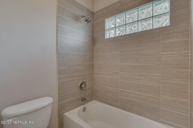 bathroom with tiled shower / bath combo and toilet