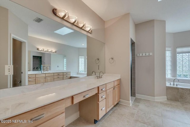 bathroom with vanity, a skylight, and a wealth of natural light