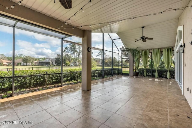 unfurnished sunroom featuring ceiling fan and vaulted ceiling