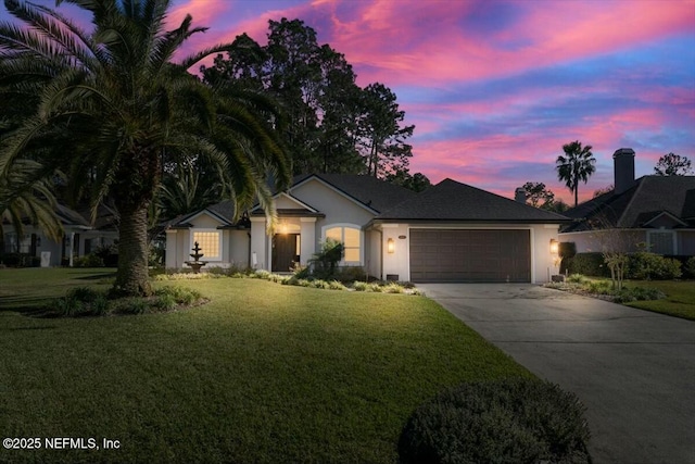 single story home with a garage and a lawn