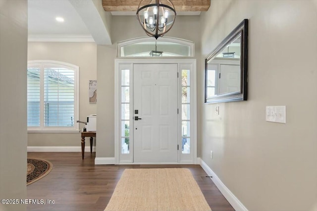 entrance foyer featuring a notable chandelier, dark hardwood / wood-style flooring, and crown molding