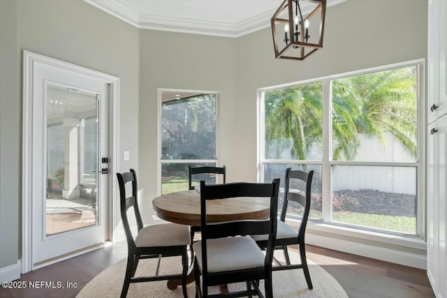 dining space with crown molding, dark hardwood / wood-style flooring, and a chandelier