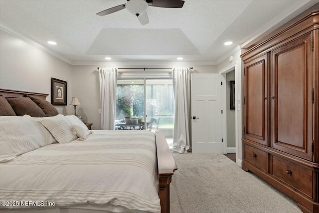 bedroom featuring a raised ceiling, ceiling fan, carpet floors, and ornamental molding