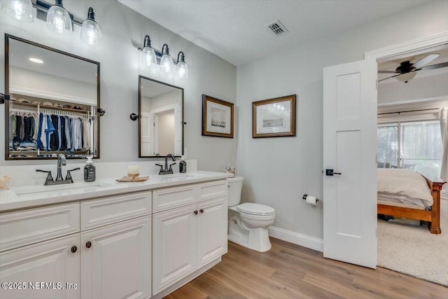 bathroom featuring hardwood / wood-style floors, vanity, toilet, and ceiling fan