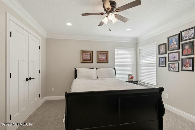 bedroom with ceiling fan, light colored carpet, ornamental molding, and a closet