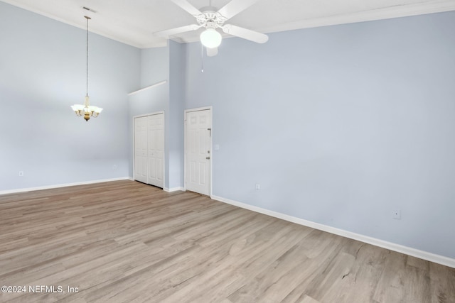 spare room featuring ceiling fan with notable chandelier, light hardwood / wood-style floors, and ornamental molding