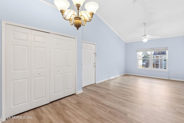 unfurnished bedroom with ceiling fan with notable chandelier, light hardwood / wood-style flooring, and vaulted ceiling