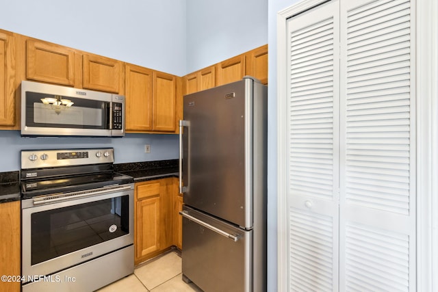 kitchen with light tile patterned floors and stainless steel appliances