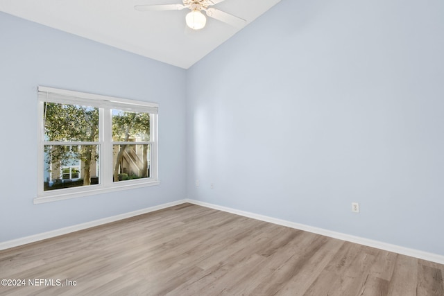 empty room with ceiling fan, light wood-type flooring, and vaulted ceiling