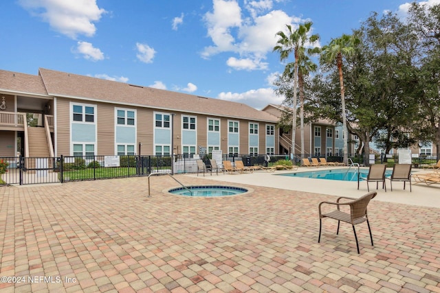 view of pool with a community hot tub and a patio