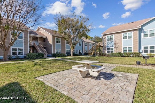 view of property's community featuring a yard and a patio