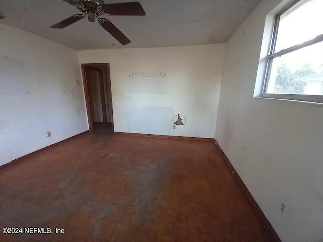 empty room with dark parquet flooring and ceiling fan