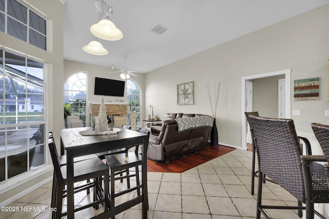 tiled dining area with ceiling fan and a healthy amount of sunlight