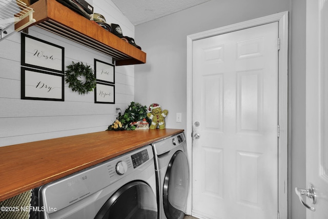 laundry room featuring washer and dryer and a textured ceiling