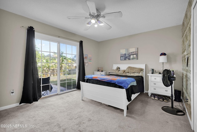 carpeted bedroom with ceiling fan, access to exterior, and a textured ceiling