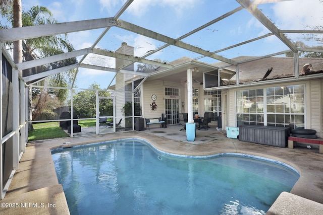 view of pool featuring glass enclosure and a patio area