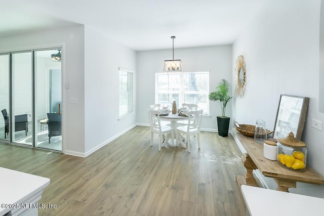 dining space featuring wood-type flooring and a notable chandelier