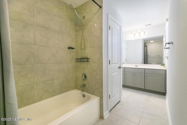 bathroom with tile patterned flooring, vanity, and tiled shower / bath