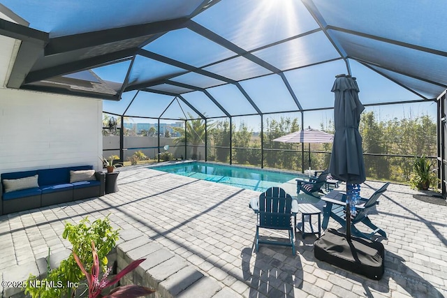 view of pool with an outdoor living space, a patio area, and a lanai