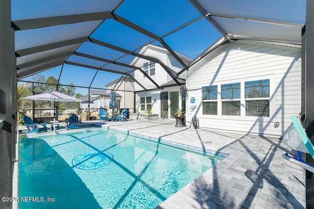 view of swimming pool with glass enclosure and a patio