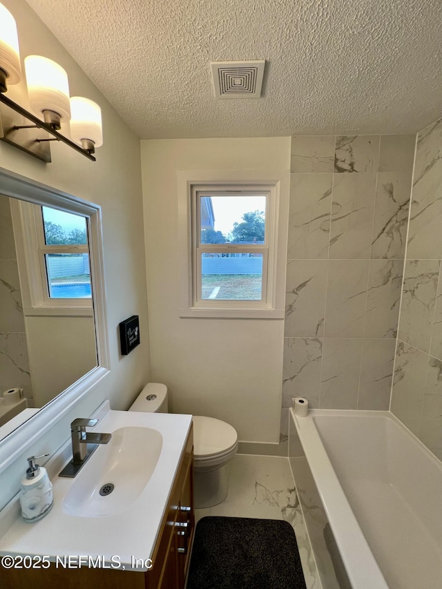 bathroom with vanity, a textured ceiling, and toilet