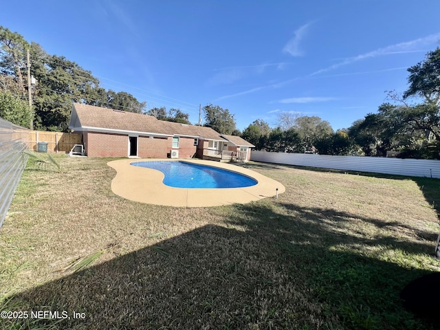 view of swimming pool with a yard