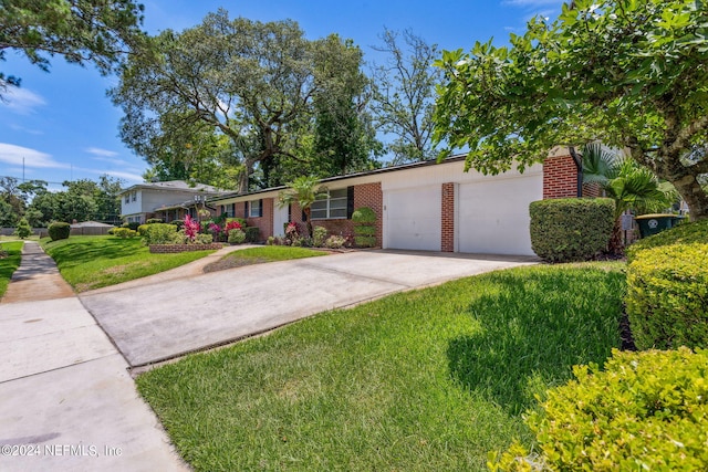 single story home featuring a garage and a front yard