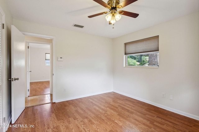 empty room with hardwood / wood-style floors and ceiling fan