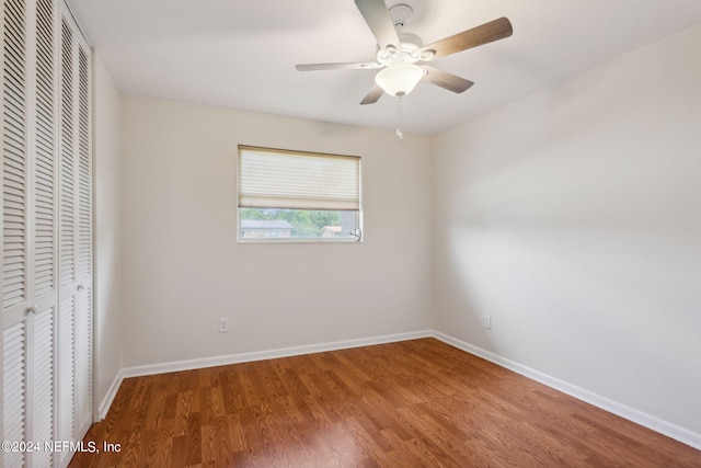 unfurnished bedroom with hardwood / wood-style flooring, ceiling fan, and a closet