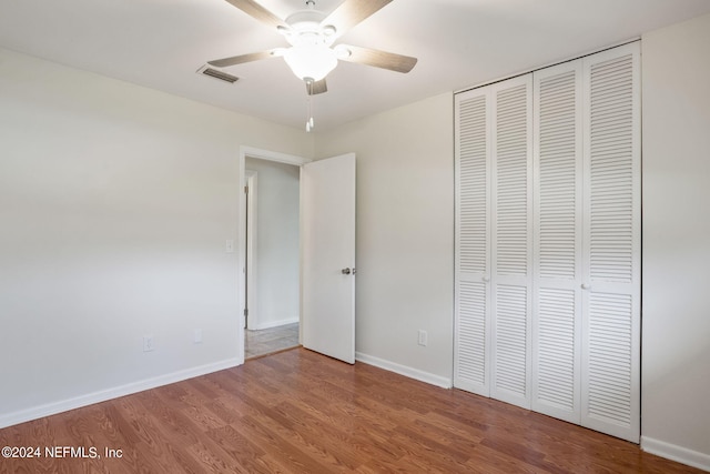 unfurnished bedroom with ceiling fan, a closet, and wood-type flooring