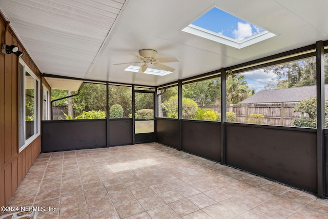 unfurnished sunroom featuring a skylight and ceiling fan